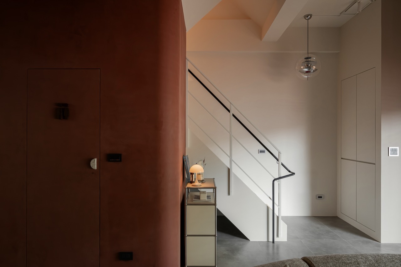 BAYIT first-floor lobby with earthen-red wall and staircase