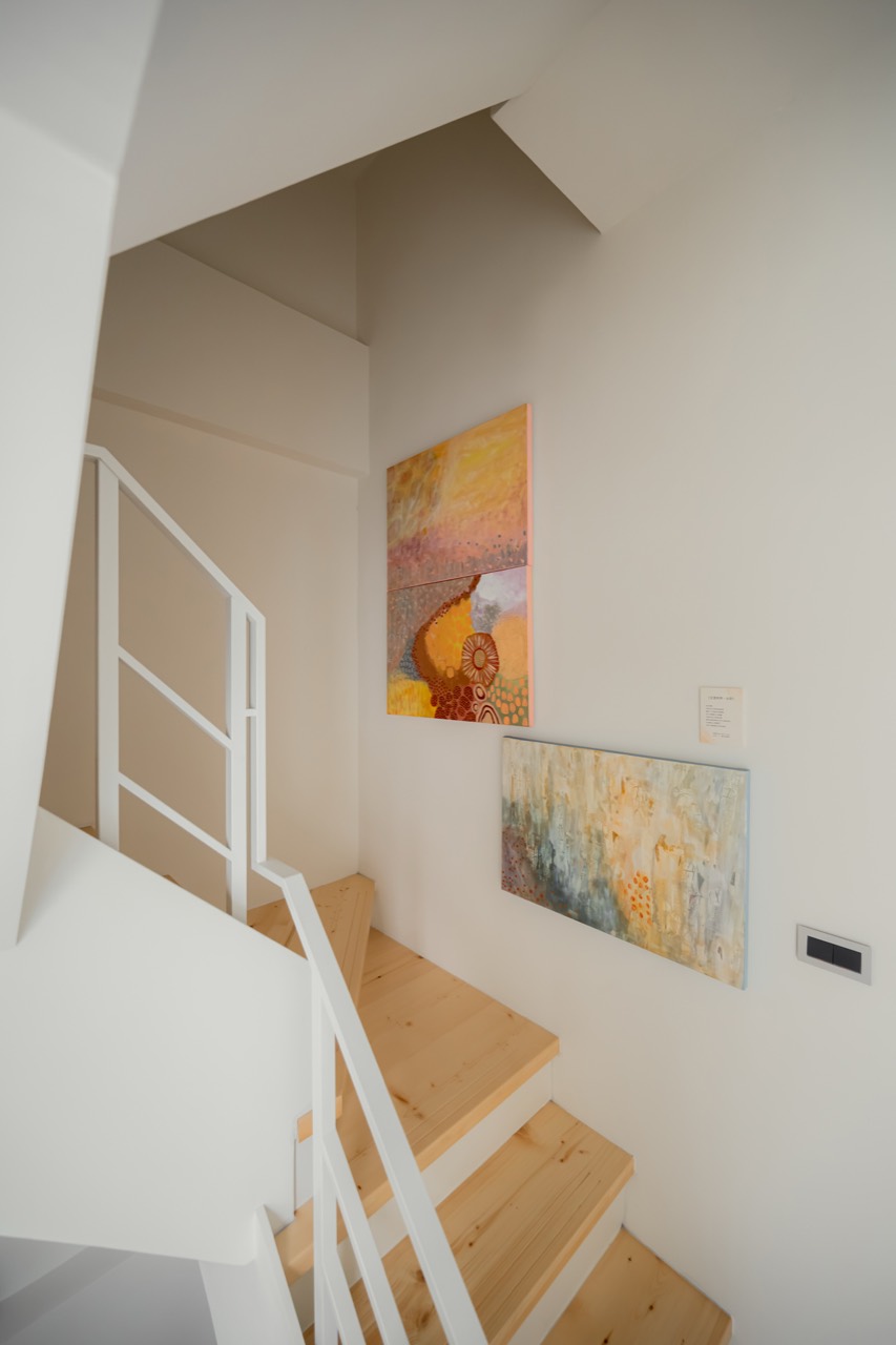 Warm-toned abstract artworks in the stairwell